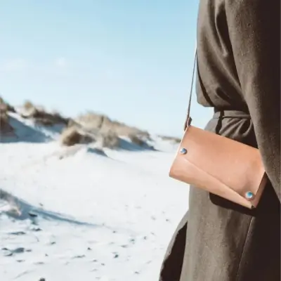 стильний клатч на моделі на фоні пляжу